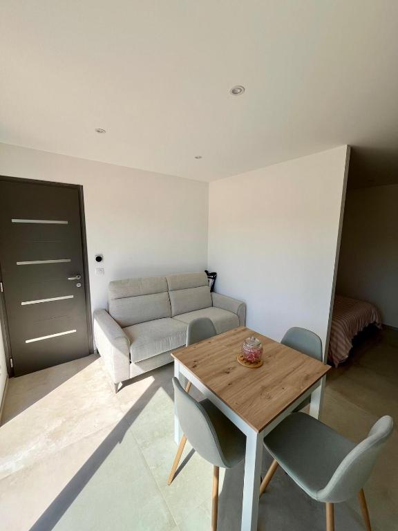 un salon avec une table et un canapé dans l'établissement Appartement au calme, à Six-Fours-les-Plages