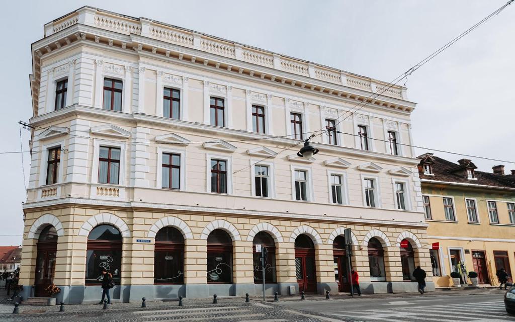 a large white building on the corner of a street at Casa Petra in Sibiu