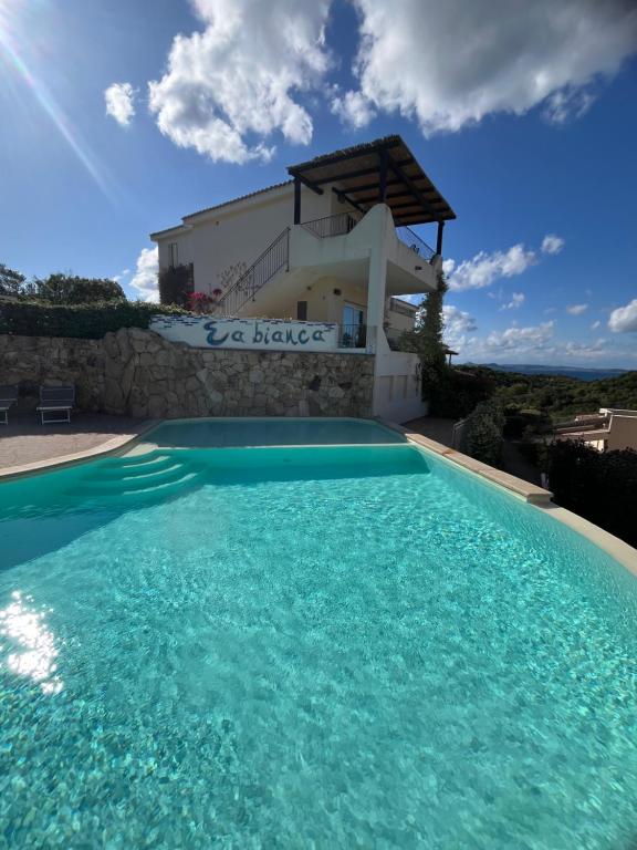 a swimming pool in front of a villa at Casa Stella Residence Ea Bianca Baja Sardinia in Baja Sardinia