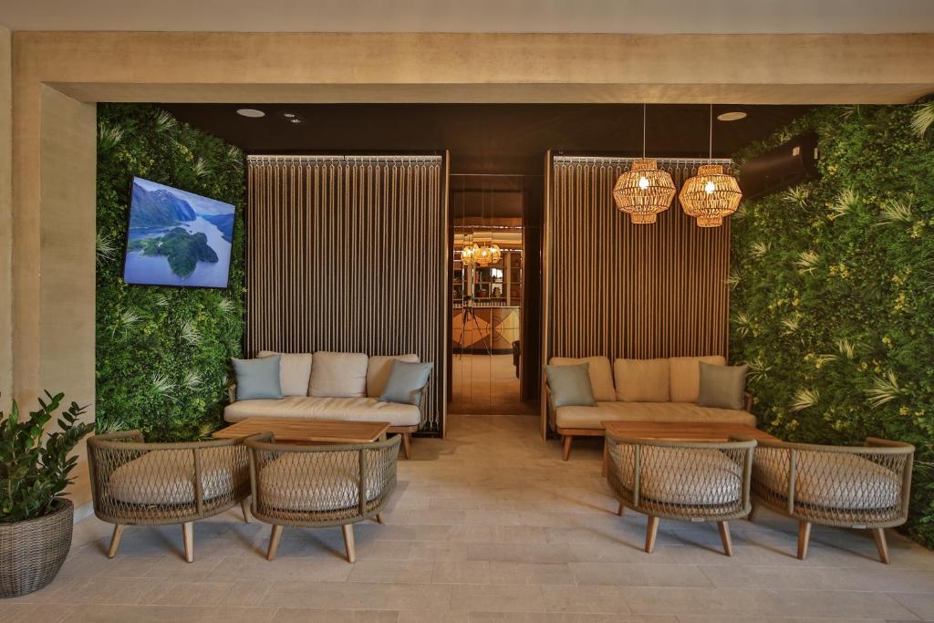 a lobby with chairs and tables and plants at Regent Resort Budva in Budva