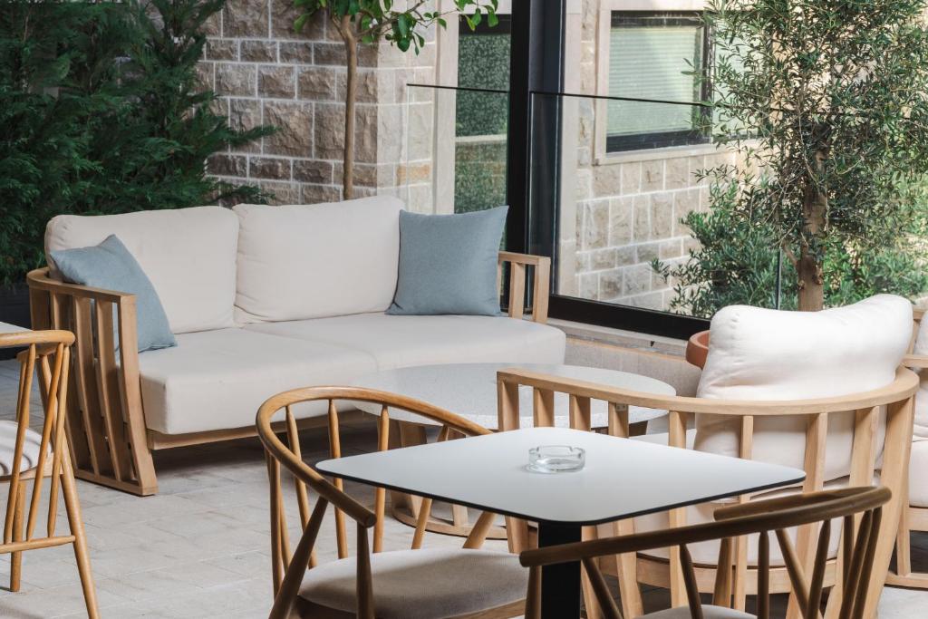 a patio with a couch and chairs and a table at Regent Resort Budva in Budva