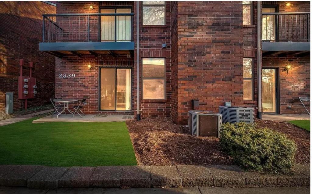 a brick building with a lawn in front of it at Property near to Airport and Free Parking in Ascalon