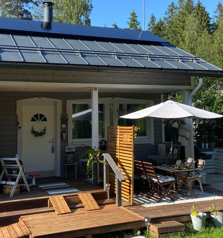 a house with a porch with a table and an umbrella at Guest House Marjala in Kotka