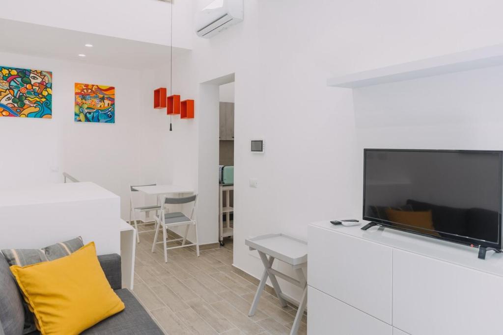 a living room with a large television and a couch at Serenello Home in Palermo