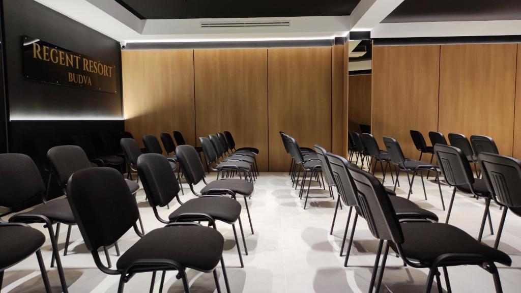 a row of chairs in a room with wooden walls at Regent Resort Budva in Budva