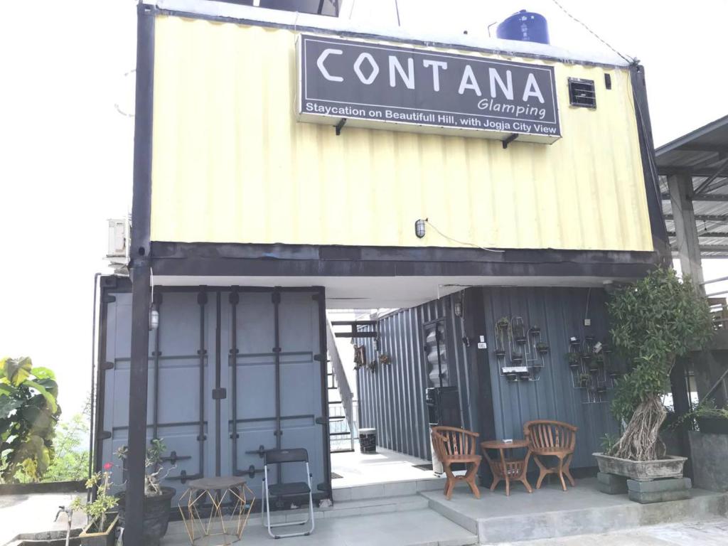 a building with chairs and a table in front of it at Contana By Travelink in Patuk