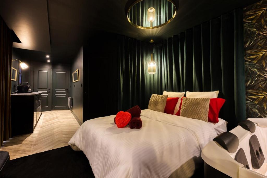 ein Schlafzimmer mit einem Bett mit zwei Stofftieren darauf in der Unterkunft Évasion Romantique Studio Vert Élégant pour 2 Proche RER C in Choisy-le-Roi