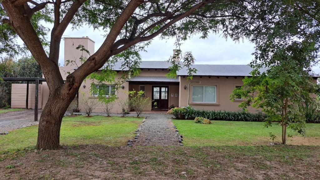 una casa con un árbol delante en Refugio en Praderas, en El Durazno