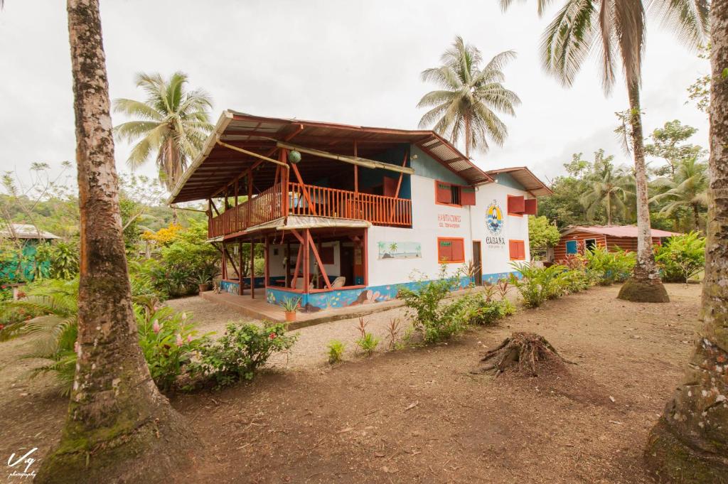 a house with a balcony and palm trees at Cabaña El Bien Germina Ya in El Valle