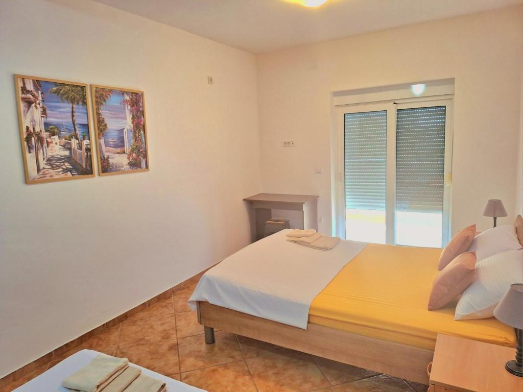 a bedroom with a large bed and a window at Sea Whisper Apartment in Budva