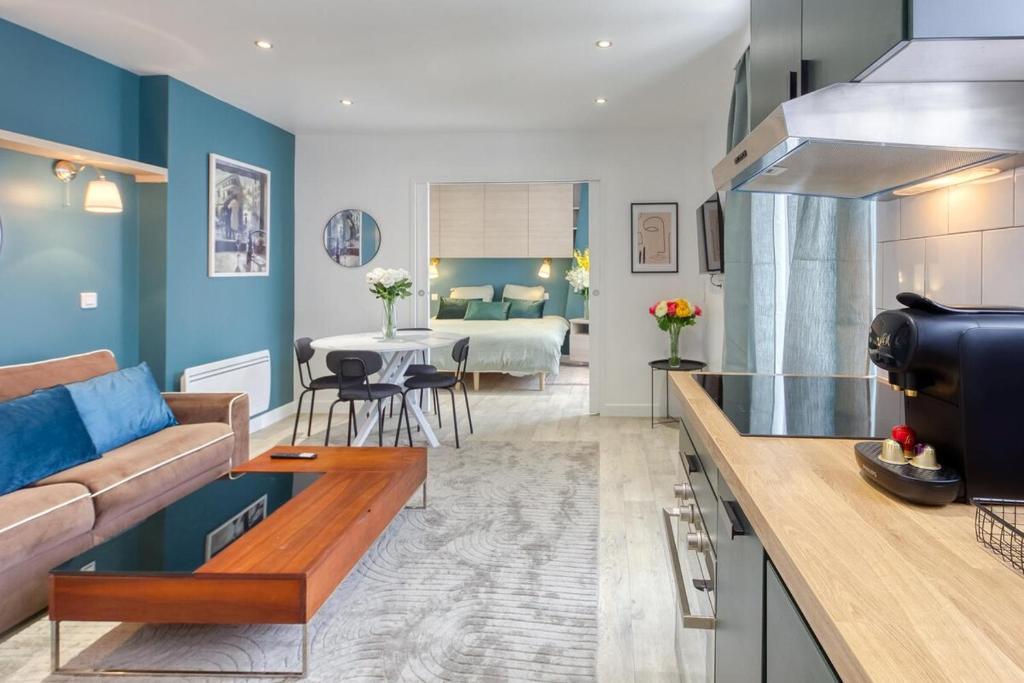 une cuisine et un salon avec un canapé et une table dans l'établissement The CGT Elegance & Comfort at the Gates of Paris, à Montreuil