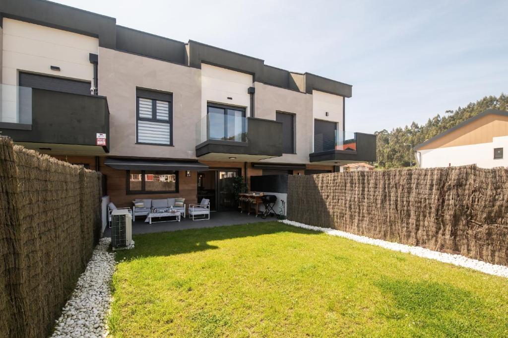 a large house with a fence and a yard at Casa vacacional Saelia in Ribadesella