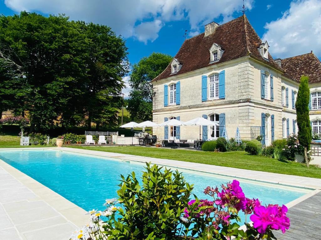 un domaine avec une piscine devant une maison dans l'établissement Château de la Forge, à Douville