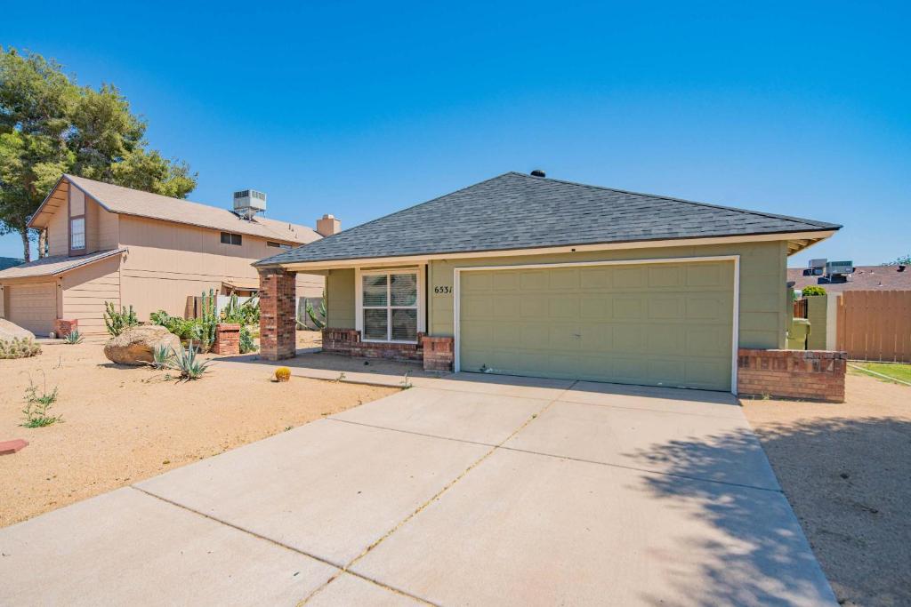 a house with a garage in a yard at Private Pool & Fully Fenced Yard Near Mntn Park in Glendale