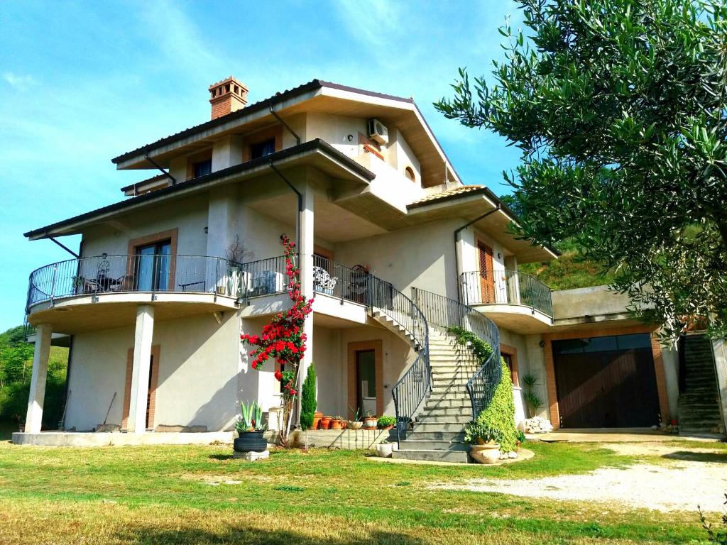 Cette grande maison blanche dispose d'une terrasse couverte et d'escaliers. dans l'établissement Tenuta Ornella, à Miglianico