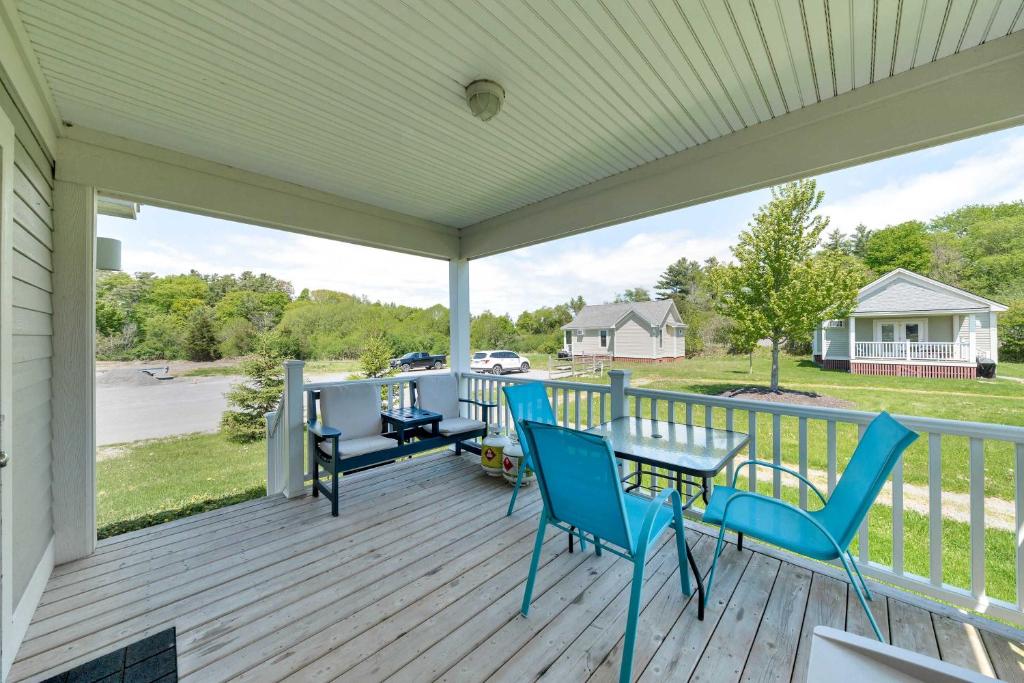 a porch with blue chairs and tables and a view at The Violet - 42 Meadow View in Cherry Valley
