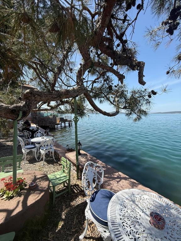 a table and chairs next to a body of water at Akkoç Heritage Suite by Lodhous in Ayvalık