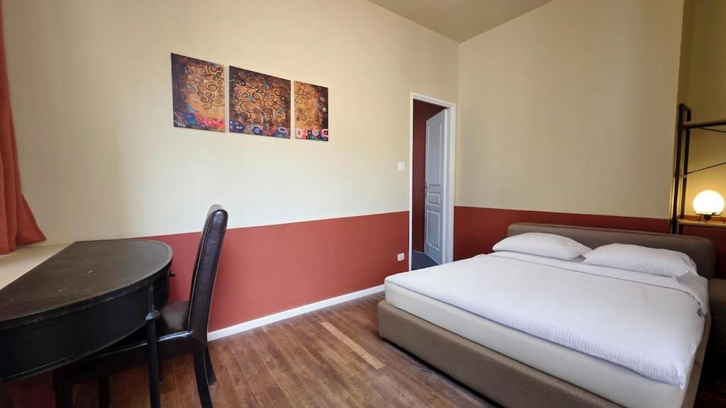 a bedroom with a bed and a desk and a table at Le Terracotta in Dieppe