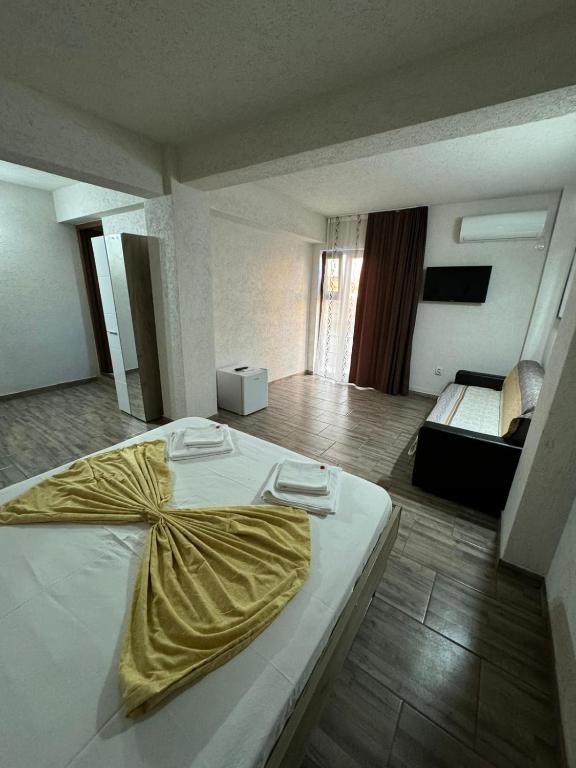 a bedroom with a bed with a yellow blanket on it at Vila Lotus in Eforie Nord