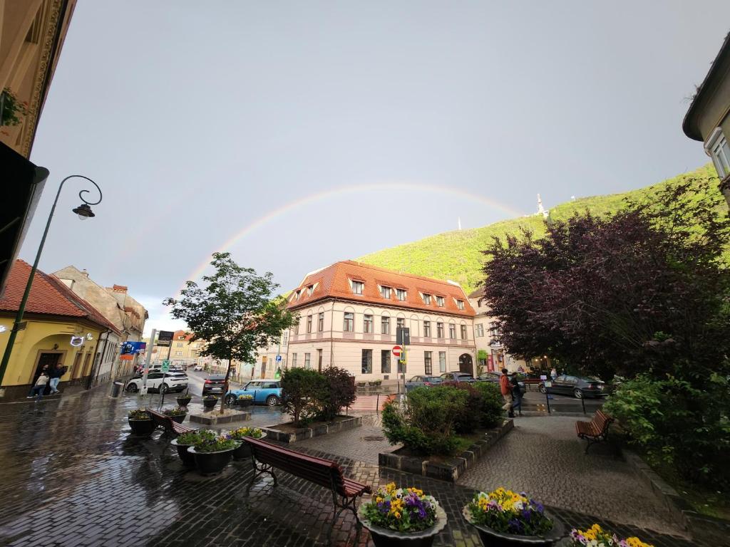 a rainbow in the sky over a city with a building at Ataraxya Boutique Hotel in Braşov