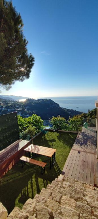 un banc en bois installé au-dessus d'une terrasse dans l'établissement Exceptional sea view apartment, Monaco 15 min, à La Turbie