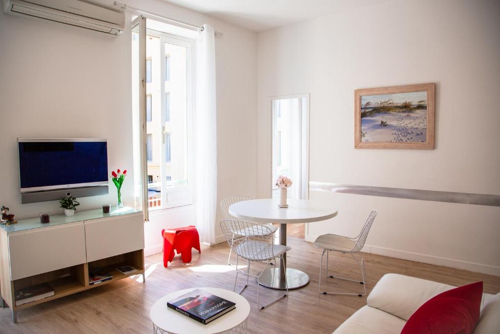 un salon avec une table et une télévision dans l'établissement Appartement 3p Paradis 5 minutes de la plage AC, à Nice