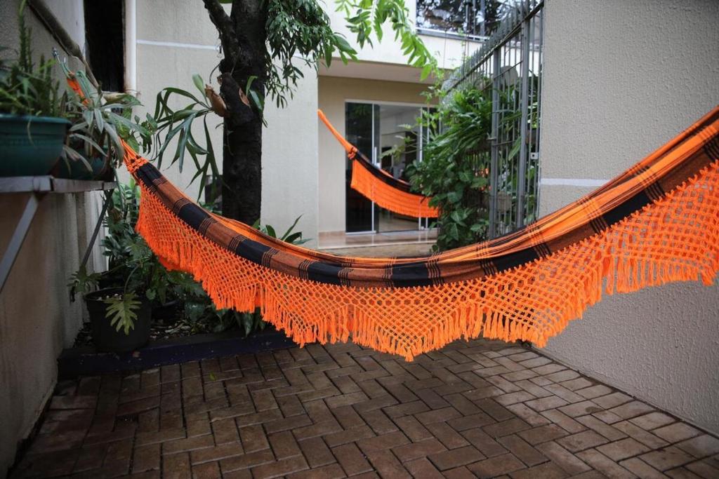 フォス・ド・イグアスにあるSobrado com 03 quartos, prox aduana da Argentinaのオレンジ色のハンモックが建物からぶら下がっている