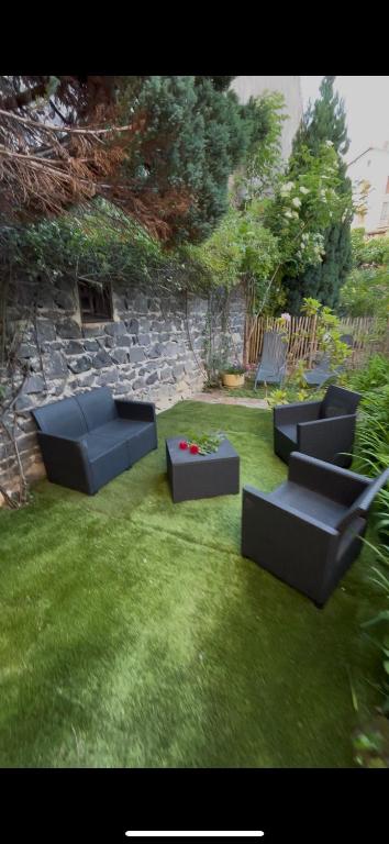 un jardin avec des canapés, une table et des chaises dans l'établissement Le Gamay - Charmant T2 avec parking et Terrasse, à Châtel-Guyon