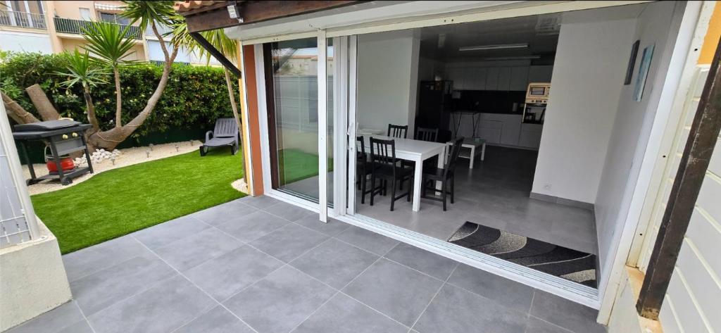 Elle offre une vue sur une terrasse avec une table et des chaises. dans l'établissement Appartement agde - terrasses de la plage, au Cap d'Agde