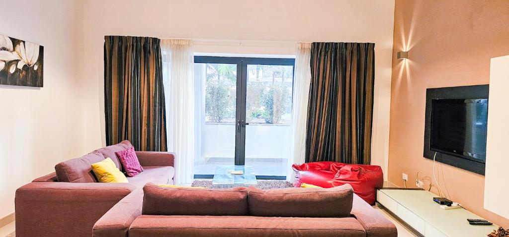 a living room with a couch and a tv at Paceville Flat Two Bedroom Two Bathrooms St Julians with Terrace and Yard Pen 2 in St Julian's