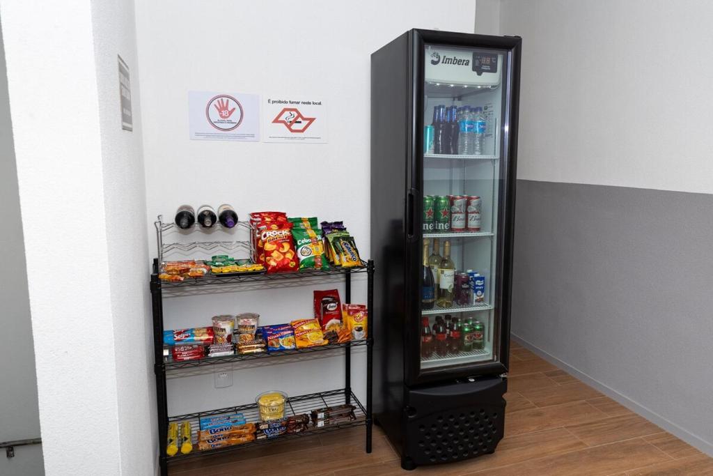 a black refrigerator with its door open and food inside at Guaja 745 - Apartamento Marie Lili in Belo Horizonte