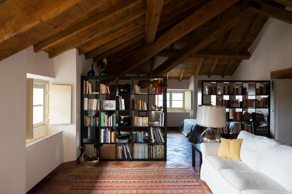 a living room with a white couch and book shelves at Castello di Rocca Grimalda in Rocca Grimalda