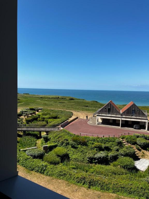 widok na budynek z oceanem w tle w obiekcie LA MER EN VUE, destination naturelle pour 2, avec WIFI et parking w mieście Wimereux