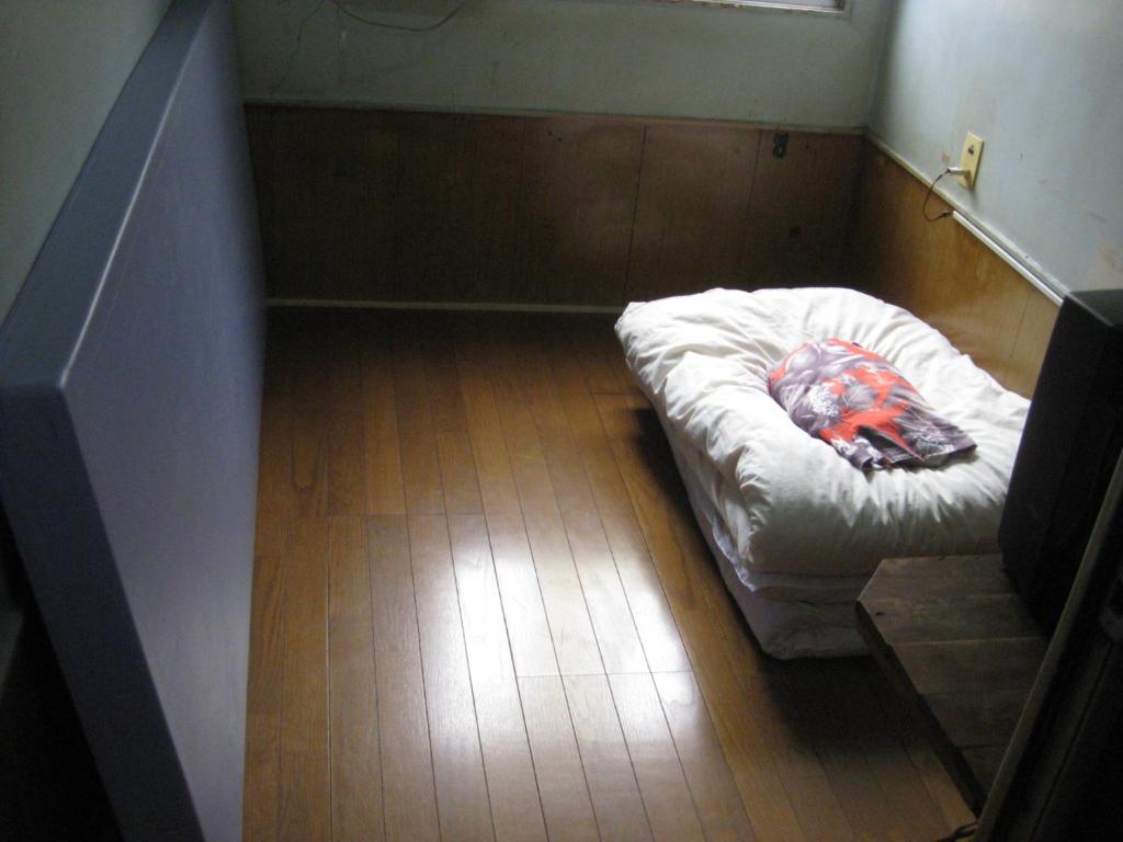 a small room with a bed on the floor at Hotel Diamond in Osaka