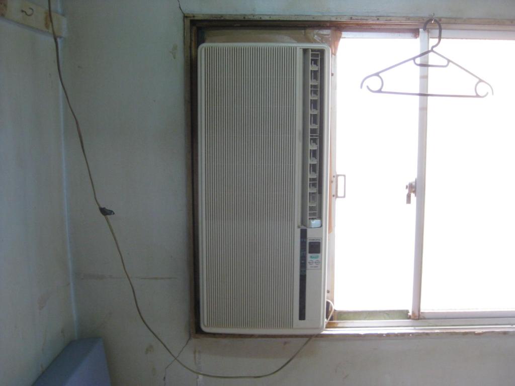 a air conditioner is sitting in a window at Hotel Diamond in Osaka