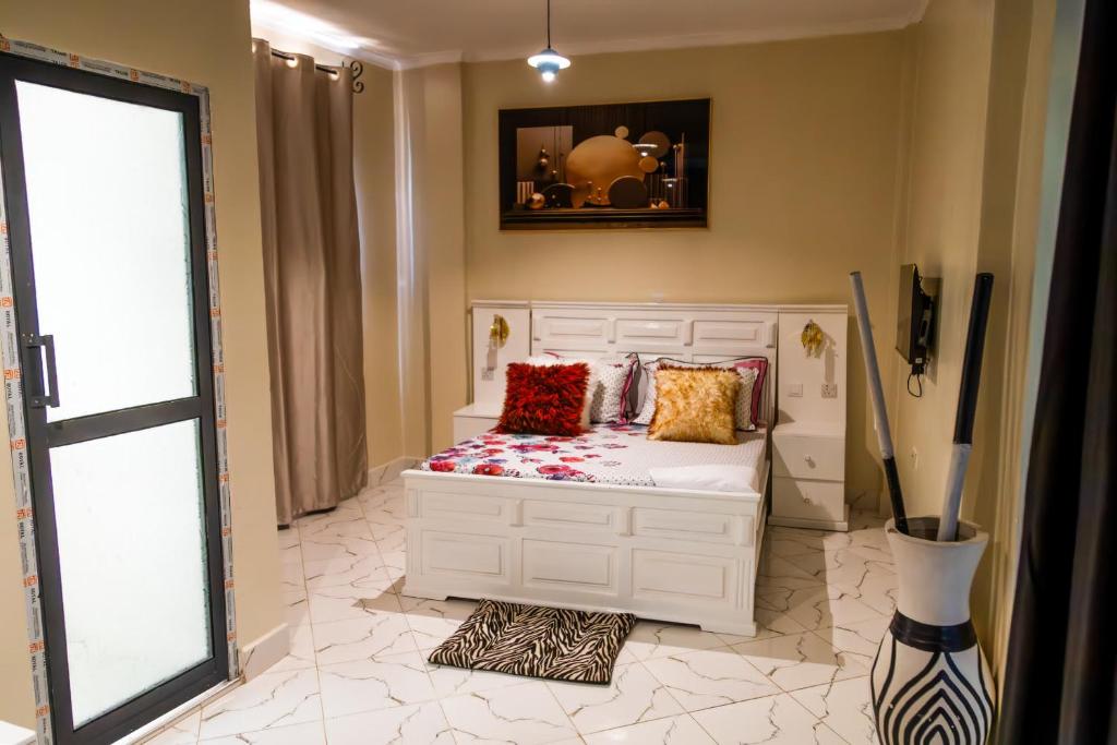 Un dormitorio con una cama blanca con almohadas. en Bienvenido a casa villa, en Arusha