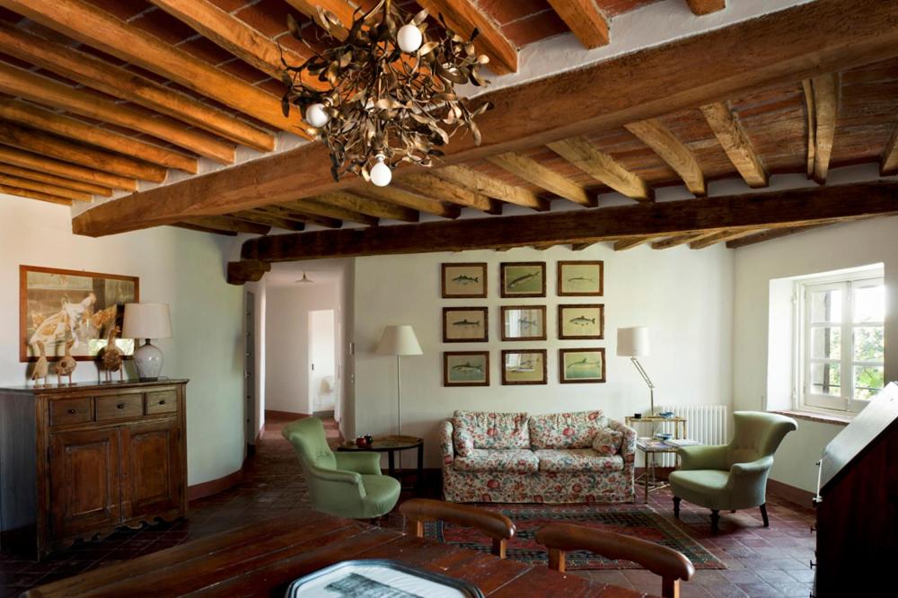 a living room with a couch and a chandelier at Castello di Rocca Grimalda in Rocca Grimalda
