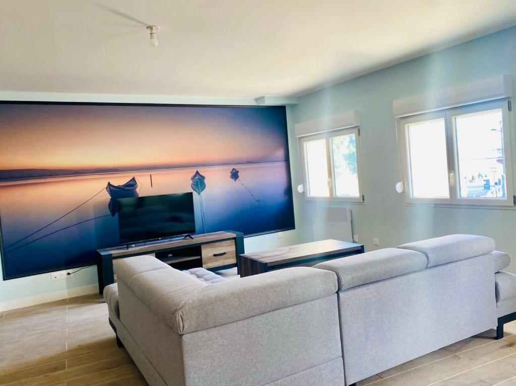 un salon avec un canapé et une télévision à écran plat dans l'établissement Les gîtes du pécheur !, au Crotoy