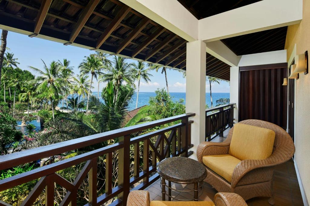 a balcony with chairs and a view of the ocean at Sheraton Senggigi Beach Resort in Senggigi