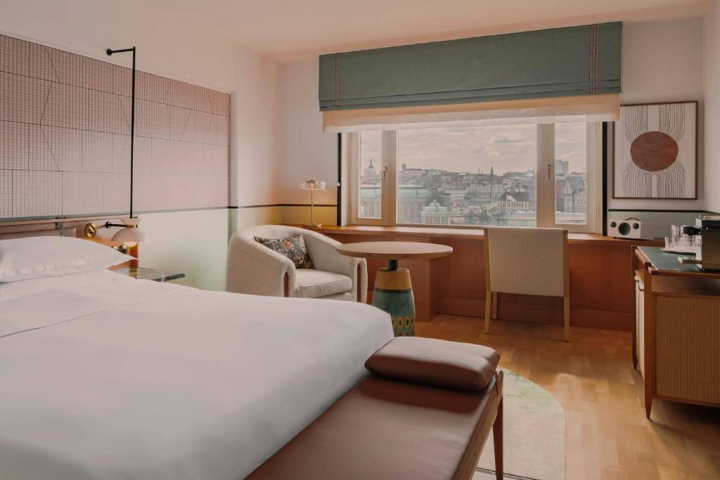 a bedroom with a bed and a table and a kitchen at Sheraton Stockholm Hotel in Stockholm