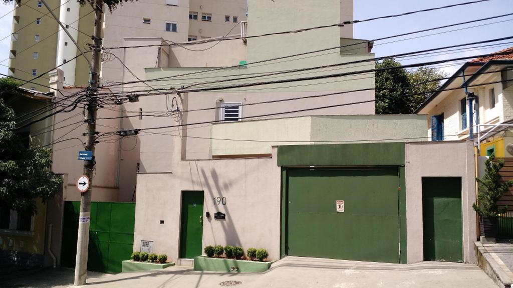 ein Gebäude mit grüner Tür auf einer Straße in der Unterkunft Hospedaria Lumo Domo Praça da Árvore in São Paulo