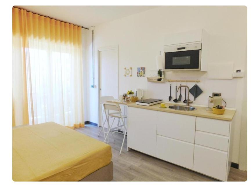 a small kitchen with a sink and a microwave at La Finestra sul Corso in Siracusa