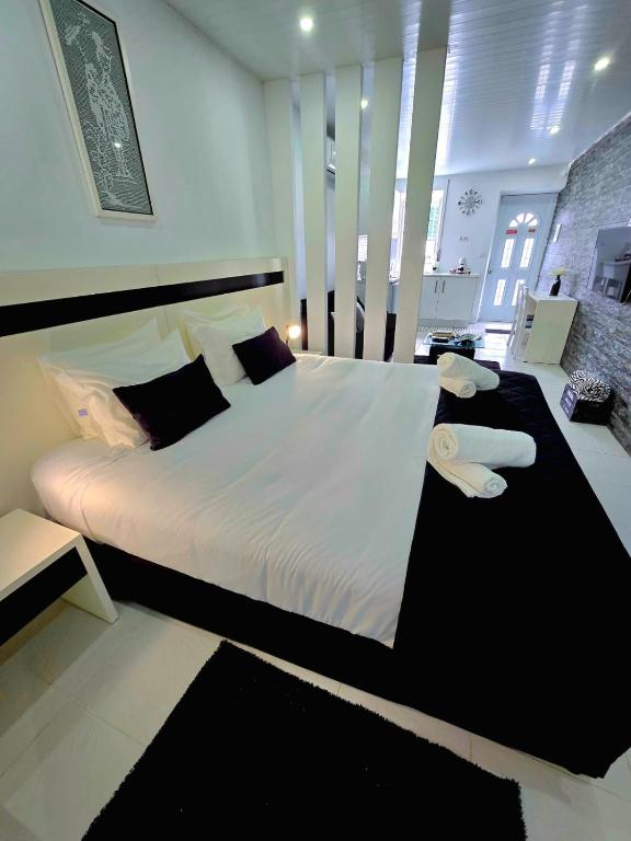 a bedroom with a large bed with white sheets and pillows at The Cedar Tree Studio in Sete Cidades
