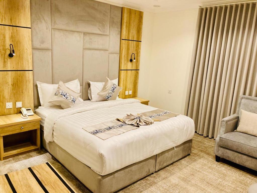 a bedroom with a large bed and a chair at تولين بارك in Taif