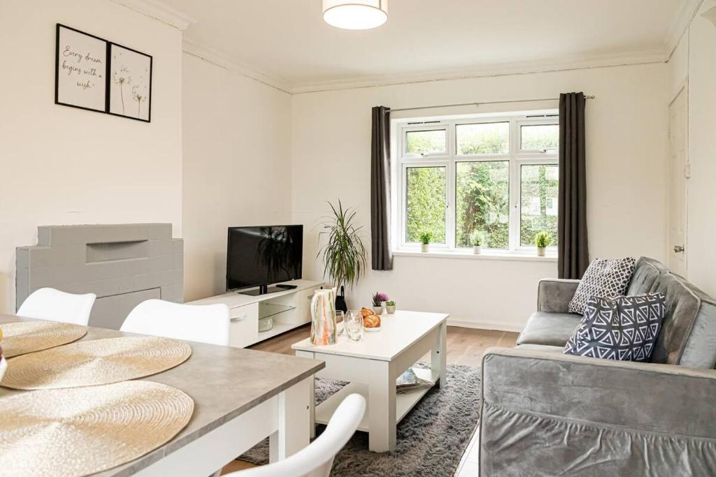 una sala de estar con una mesa y un sofá en 5 Bed House - Free Parking, en Drayton