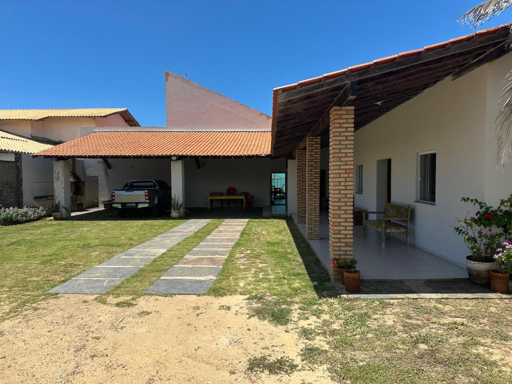 ein Haus mit einer Terrasse und einem Rasenhof in der Unterkunft Casa beira-mar - Luis Correia in Luis Correia