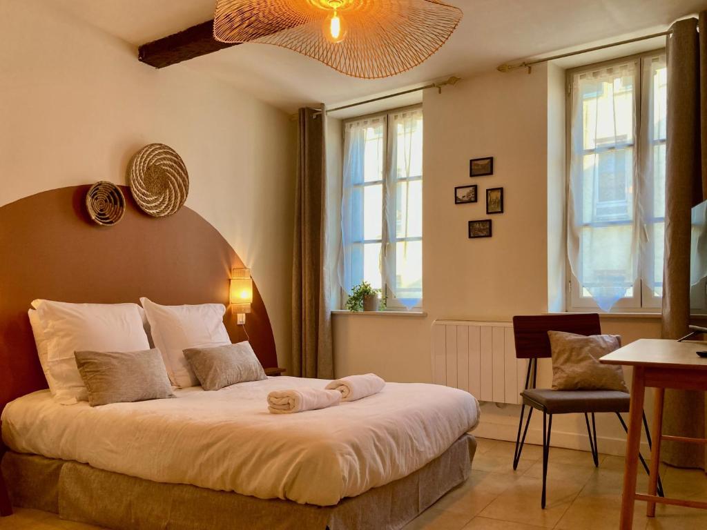 - une chambre avec un grand lit dans une pièce dotée de fenêtres dans l'établissement Le Repaire Légendaire, à Carcassonne