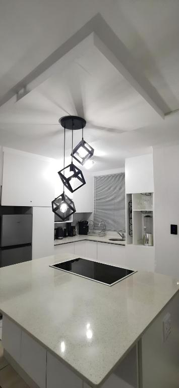 a kitchen with a white counter top with two lights at Sandhurst Luxury Accommodation Self-Catering Suites in Pietermaritzburg in Pietermaritzburg