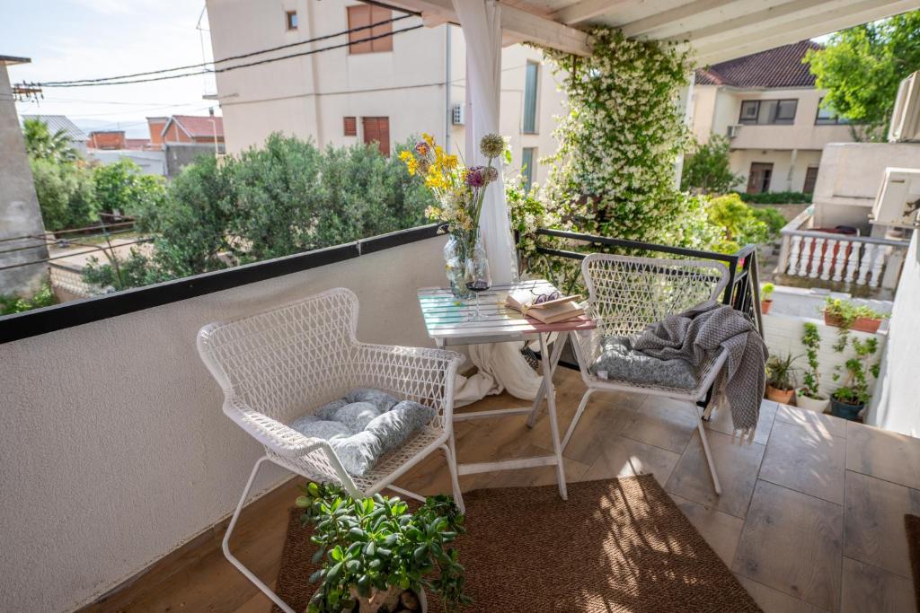 a patio with a table and two chairs on a balcony at Guest house Mediterranea in Pakoštane