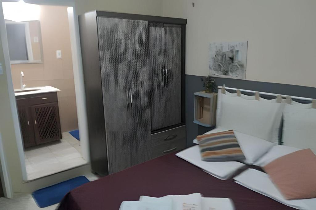 1 dormitorio con 1 cama con armario negro en Oceana Suites Pousada Meireles, en Fortaleza